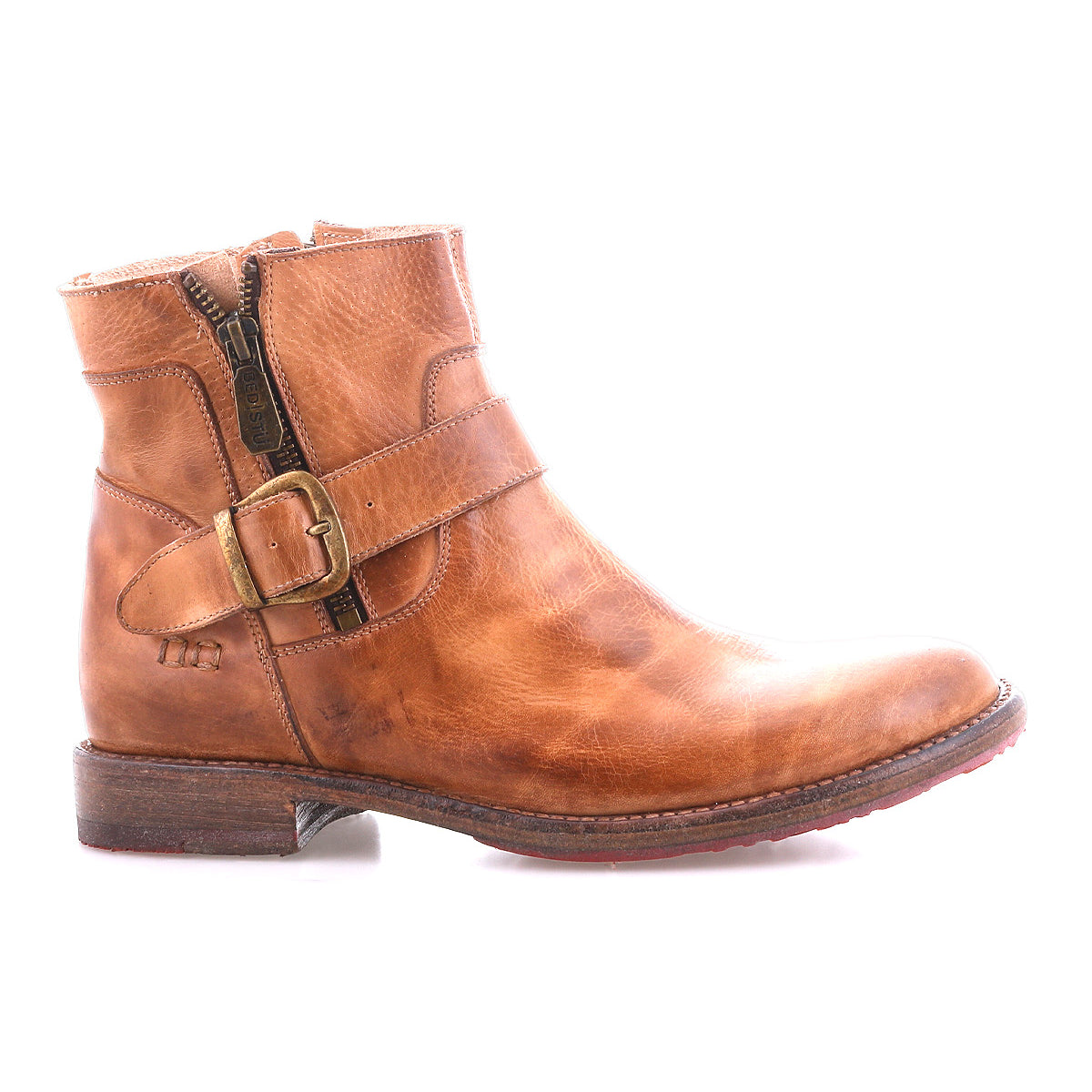 The Bed Stu Becca is a brown leather short engineer boot with an ankle buckle, side zipper, and buckle strap, shown solo against a white background.