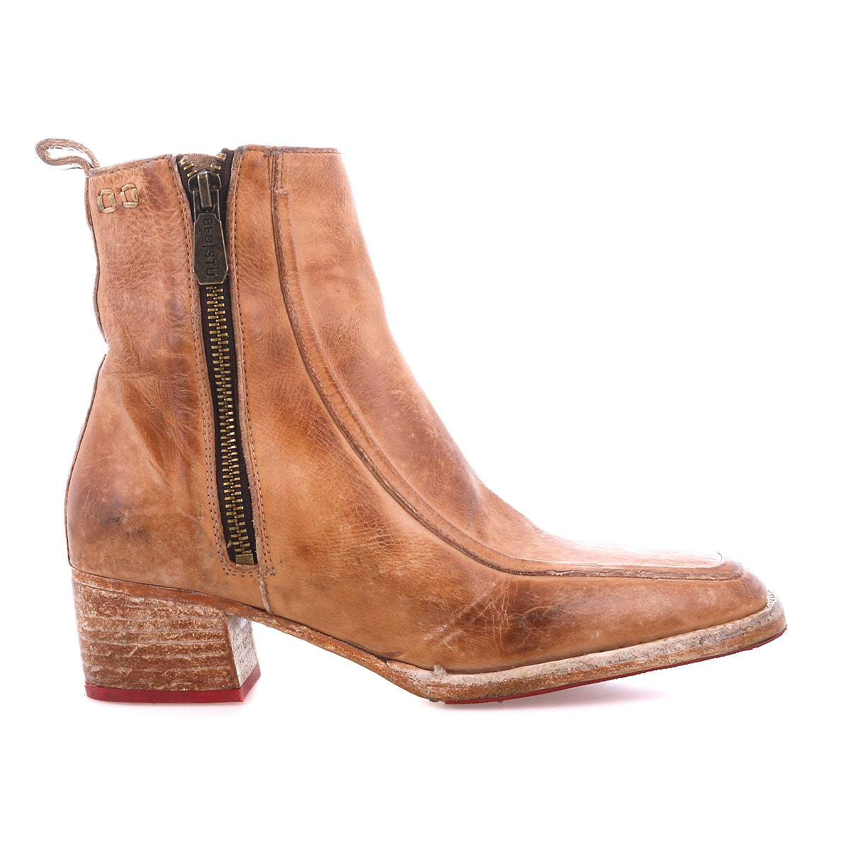 The Bed Stu Bitsy is a tan leather ankle boot featuring a side zipper, stacked wooden heel, and slightly worn hand-finished leather for a timeless look.
