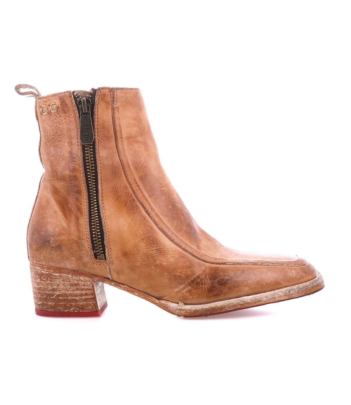 The Bed Stu Bitsy is a tan leather ankle boot featuring a side zipper, stacked wooden heel, and slightly worn hand-finished leather for a timeless look.