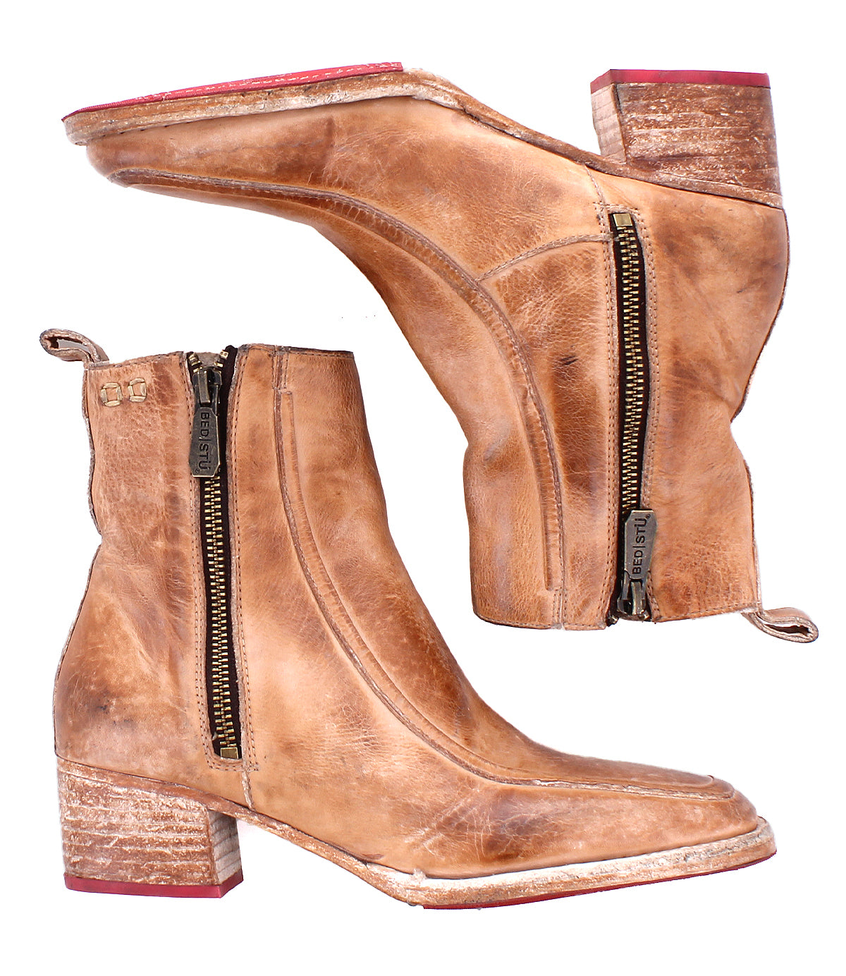 The Bed Stu Bitsy is a pair of tan hand-finished leather ankle boots with stacked wooden heels, visible side zippers, red soles, and distressed detailing.