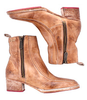 The Bed Stu Bitsy is a pair of tan hand-finished leather ankle boots with stacked wooden heels, visible side zippers, red soles, and distressed detailing.