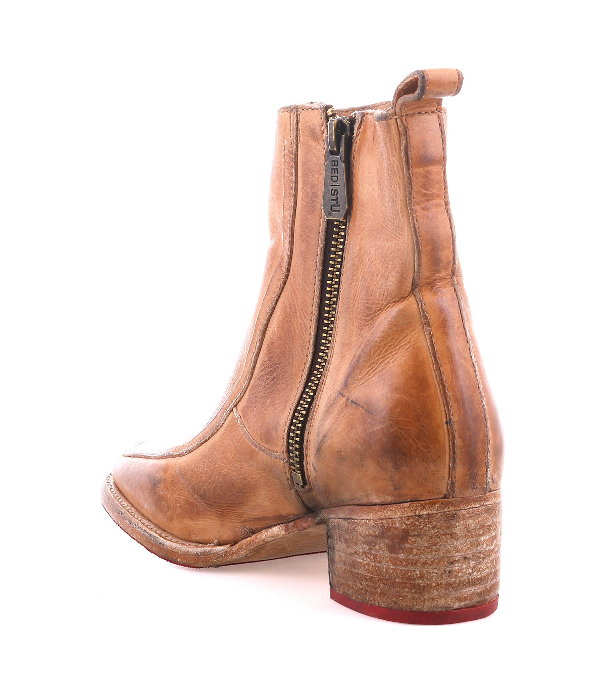 The Bed Stu Bitsy is a tan hand-finished leather ankle boot featuring a side zipper, stacked wooden heel, visible stitching, and a worn sole.