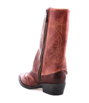 The Bed Stu Blind is a brown distressed leather boot with a Western silhouette, decorative stitching, side zipper, rounded toe, and low heel, displayed at an angle on a white background.