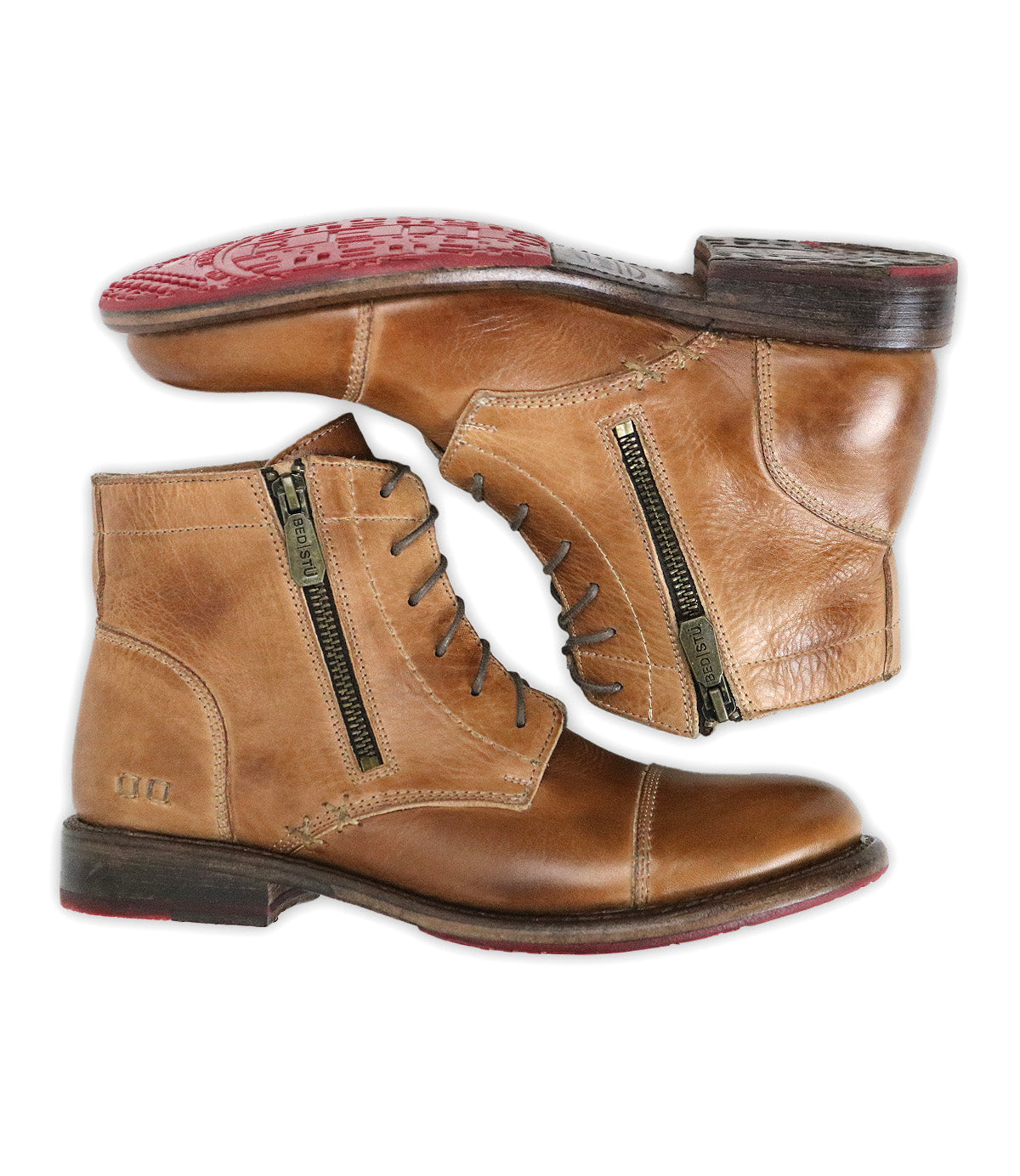 The Bed Stu Bonnie II is a pair of tan leather combat ankle boots featuring cap toes, side zippers, lace-up fronts, dark brown soles, and red tread on the bottom.