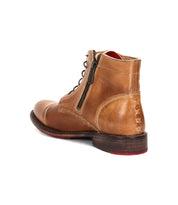 The Bed Stu Bonnie II is a brown leather combat ankle boot with a cap toe, side zipper, and decorative heel stitching, displayed from a rear side angle on a white background.