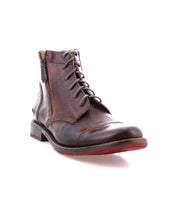 The Bed Stu Bonnie II is a brown leather lace-up combat ankle boot with a cap toe, side zipper, decorative stitching, and a low heel, shown against a white background.