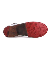 The Bed Stu Bonnie II dress shoe features a red and brown sole with embossed text, geometric shapes, and a Goodyear welted outsole for enhanced durability.