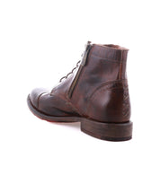 The Bed Stu Bonnie II is a brown leather combat ankle boot with a cap toe, side zipper, visible stitching, and a low wooden heel, displayed against a white background.
