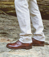 A man showcasing his Bed Stu leather boots in the Bradley style, with exceptional craftsmanship and a comfortable cushioned insole, standing on a rock.