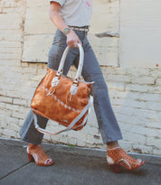 Person walking with a large two-toned leather Bruna bag by Bed Stu and patterned high-heel shoes.