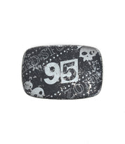 The Bed Stu 95 Buckle is a rectangular, black belt buckle with a distressed finish, featuring the number "95" and skull graphics for an edgy look.
