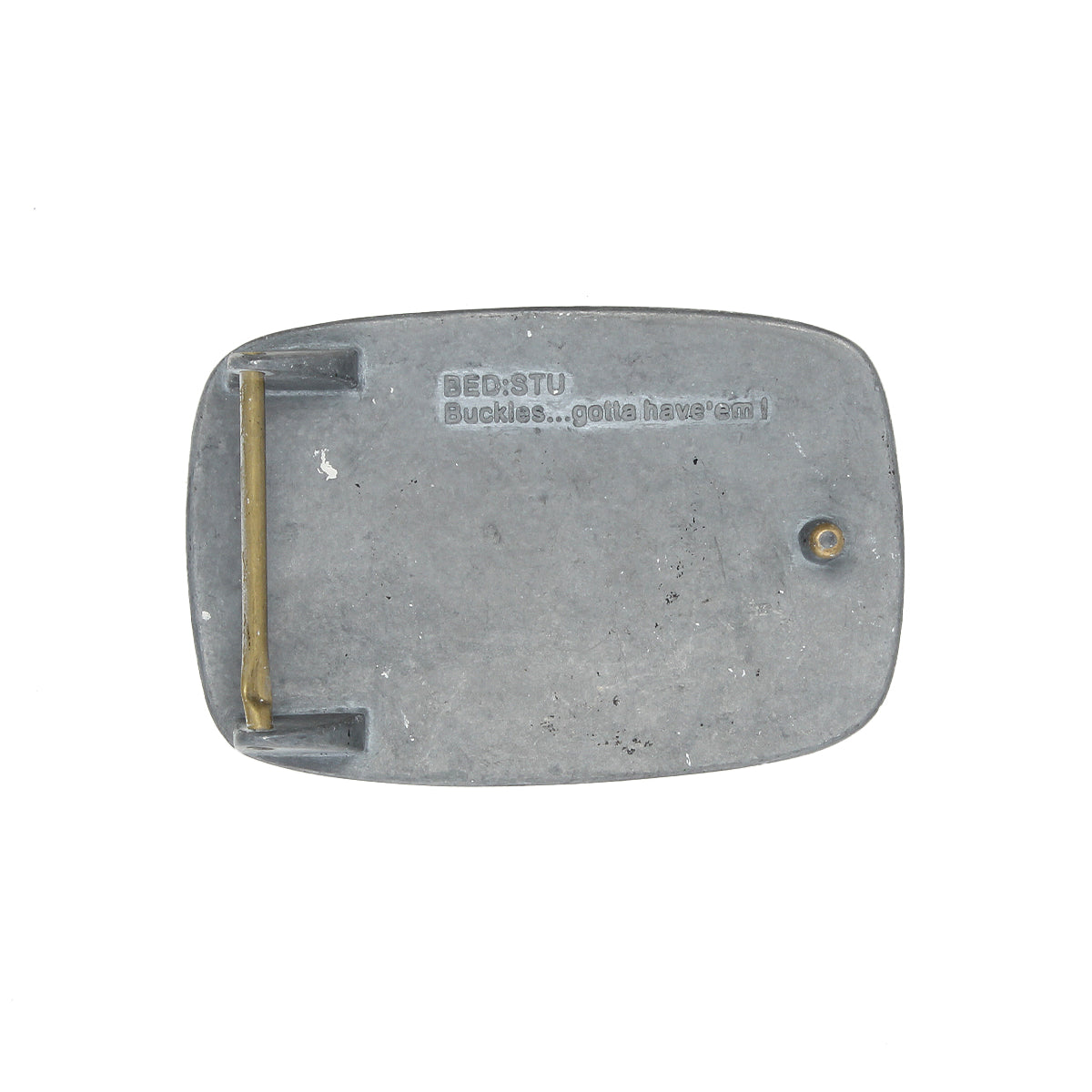The Bed Stu 95 Buckle is a rectangular metal belt buckle featuring a brass hinge and engraved text on the back, adding rugged, distinctive style to any outfit.
