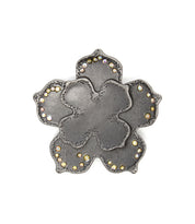 The Bed Stu Flower Sparkle Buckle features a metal, flower-shaped design with textured petals and small round gemstones along the edges, giving it a vintage-inspired look.