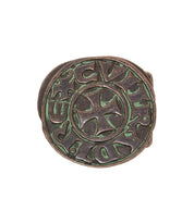 The Bed Stu Greek Cross belt buckle features a round bronze design with a raised cross at the center and engraved, stylized text encircling it.