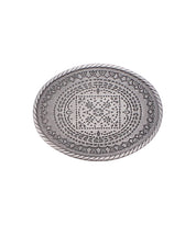 The Tribe Buckle by Bed Stu features an oval-shaped silver design with intricate engraved patterns and a braided border, echoing rustic charm inspired by ranch heritage.