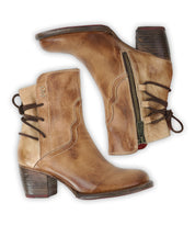 The Bed Stu Cable boots are brown hand-finished leather ankle boots with chunky heels, dark laces, decorative stitching, and side zippers that add subtle Western flair, shown on a white background.