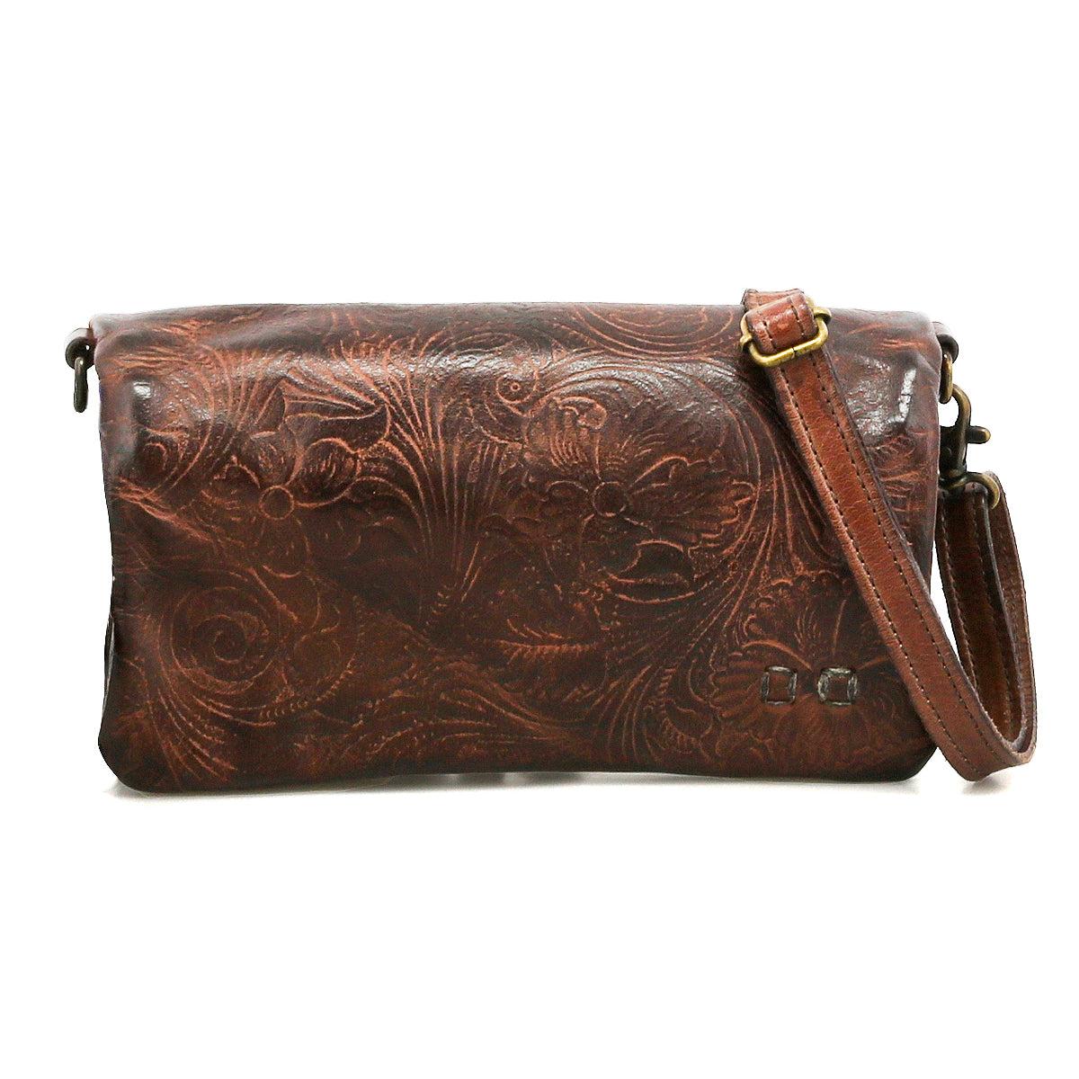 The Bed Stu Cadence EM is a brown leather clutch bag with an adjustable strap and embossed floral pattern, shown against a white background.