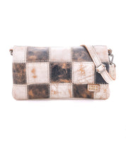 Cadence PW by Bed|Stü is a rectangular shoulder bag crafted from vegetable-tanned leather squares in brown, cream, and tan patchwork. It features a matching adjustable strap and a small tag detail on the lower right.