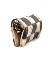 A small, worn leather Bed Stu Cadence PW crossbody bag featuring a black and white checkered pattern and a partially visible metal clasp.