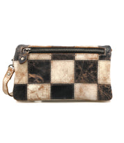 The Bed Stu Cadence PW is a rectangular patchwork clutch purse featuring a black and beige checkerboard pattern, front zipper pocket, and left-side wrist strap—ideal as a stylish travel wallet for your essentials.