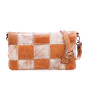Introducing the Cadence PW by Bed|Stü—a rectangular shoulder bag adorned with a striking patchwork of brown and metallic silver squares, detailed with distinctive zigzag stitching and an adjustable strap. Crafted from premium vegetable-tanned leather, this versatile piece seamlessly transitions from a crossbody clutch to a chic accessory for any occasion, blending timeless style with modern functionality.