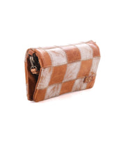 The Bed|Stü Cadence PW is a brown and white checkered patchwork leather clutch bag featuring a unique patchwork design, shown closed and standing upright on a white background.