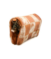 The Bed Stu Cadence PW is a small rectangular patchwork clutch crafted from tan and cream leather with visible stitching and a metal clasp at one end.