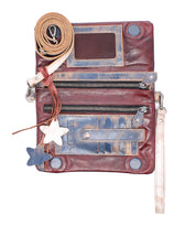 The Bed Stu Cadence is a worn vegetable-tanned leather crossbody clutch featuring zippers, card slots, a clear ID window, detachable strap, and two star-shaped keychains.