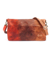 The Cadence shoulder bag by Bed|Stü features brown and reddish vegetable-tanned leather, an adjustable strap, and metal clasp hardware, shown against a white background.