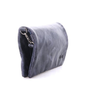 The Cadence by Bed Stu is a small, dark blue leather compact wallet with a partially visible metal clasp, shown against a white background.
