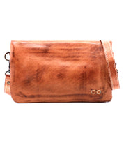 The Cadence by Bed Stu is a rectangular brown leather crossbody bag with a long strap and a small metallic logo on the bottom right—ideal for carrying as a compact wallet on the go.