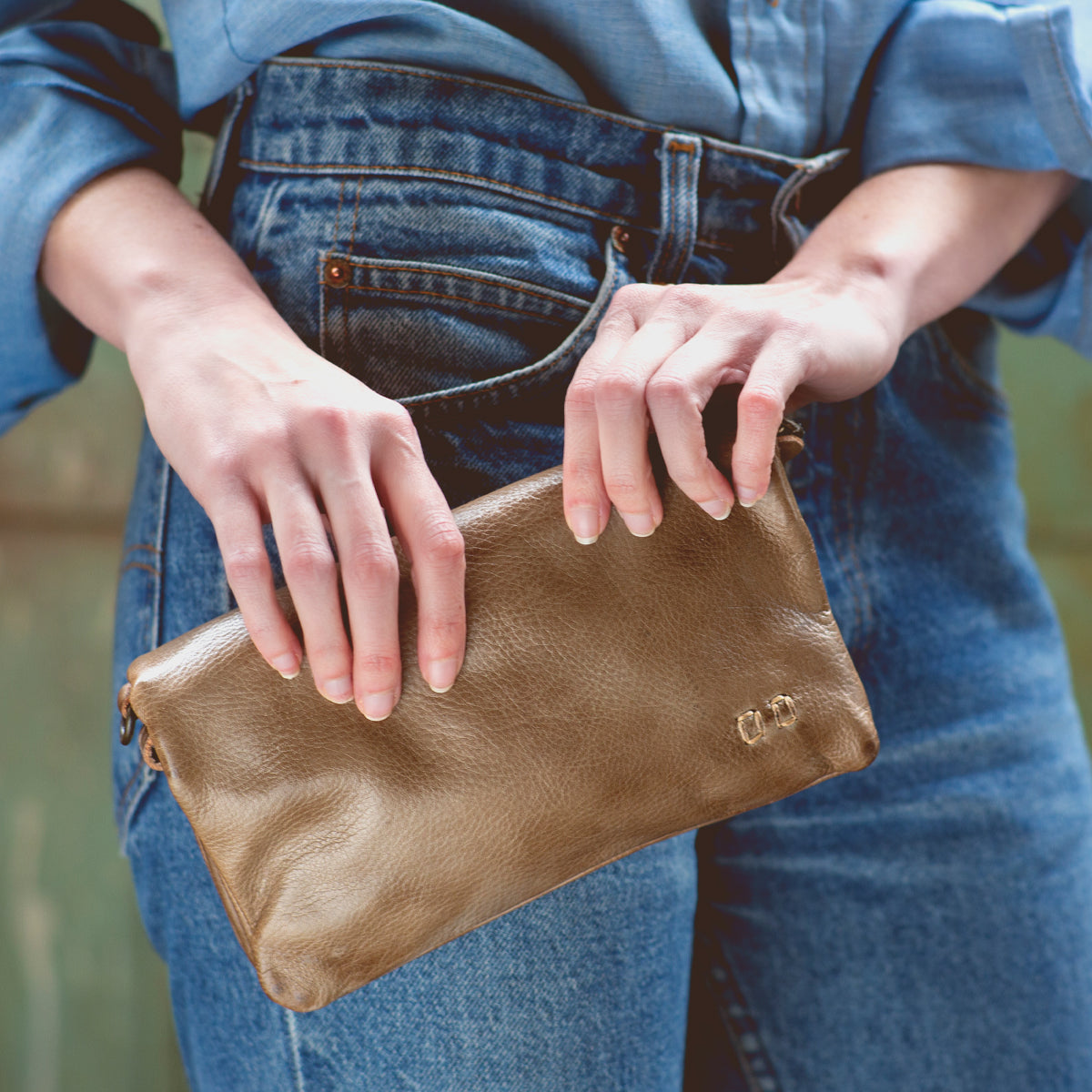 A woman holding a Cadence leather clutch wallet by Bed Stu.