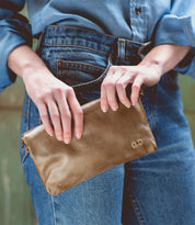 A woman holding a Cadence leather clutch wallet by Bed Stu.