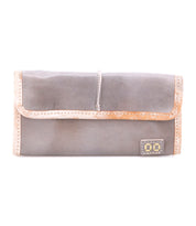 The Bed Stu Canton is a rectangular gray 2-in-1 leather wallet with tan trim, card slots for easy organization, and a small decorative patch in the bottom right—combining style and functionality.