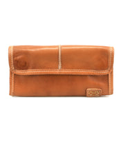 The Bed Stu Canton is a tan compact leather wallet featuring visible stitching and a small rectangular logo patch in the bottom right corner, shown against a white background.