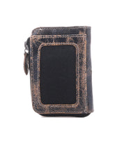 The Bed Stu Carrie is a brown compact leather wallet with a zipper and a black fabric front panel, featuring convenient card slots. It’s shown against a white background.