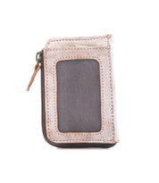 The Bed|Stü Carrie is a small, light brown compact leather wallet featuring a transparent mesh ID window and multiple card slots, displayed standing upright on a white background.