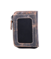 The Bed Stu Carrie is a compact leather wallet in brown and black with a zipper closure, multiple card slots, and a front transparent ID window, shown on a white background.