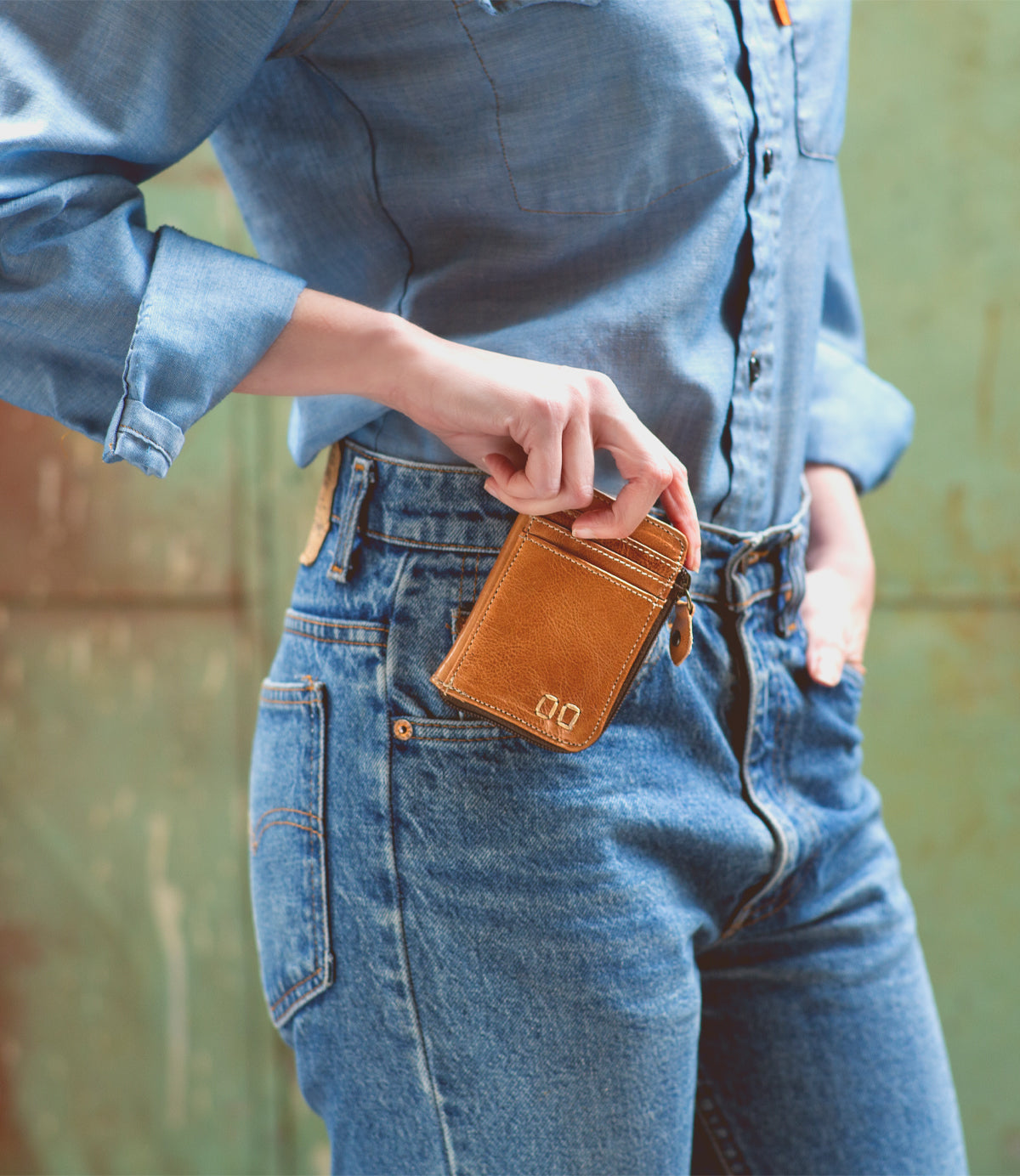 A woman is holding a Bed Stu Carrie wallet in her jeans.
