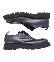 The Casotto boots by Bed Stu are black leather men's lace-up boots with thick soles, displayed from the side and facing opposite directions on a white background. Their Italian craftsmanship and retro flair make them a standout choice.