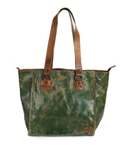 The Celindra LTC by Bed Stu is a green and brown leather zip-top tote, featuring two brown shoulder straps, visible stitching, and whipstitch detailing for a spacious and stylish finish.