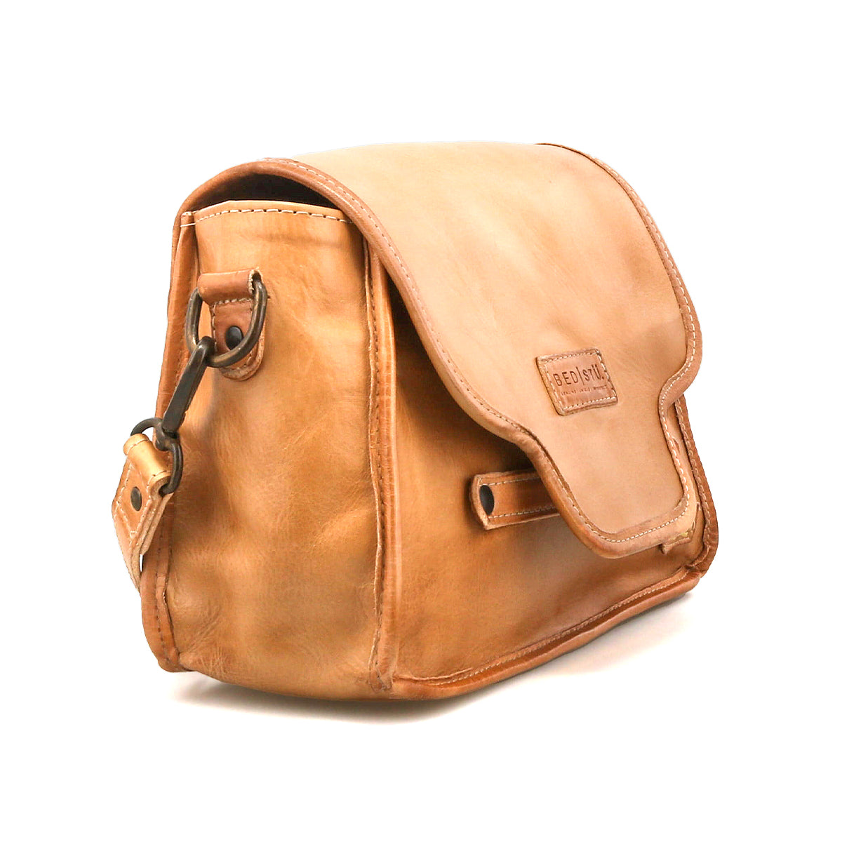 The Bed Stu Ceremonious is a light brown preppy flap-top bag with a side magnetic closure, organized interior, and embossed front logo.