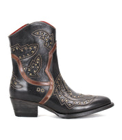 The Bed Stu Chamise is a black leather western boot with brown accents, decorative stitching, gold studs, striking leather inlays, a snip toe, and an angled heel—shown here in side profile.