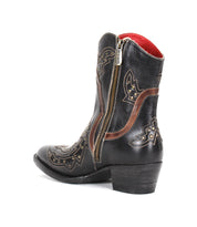 The Bed Stu Chamise boot is shown against a white background, featuring black leather, brown embroidery, gold studs, a snip toe, side zipper, and low heel.