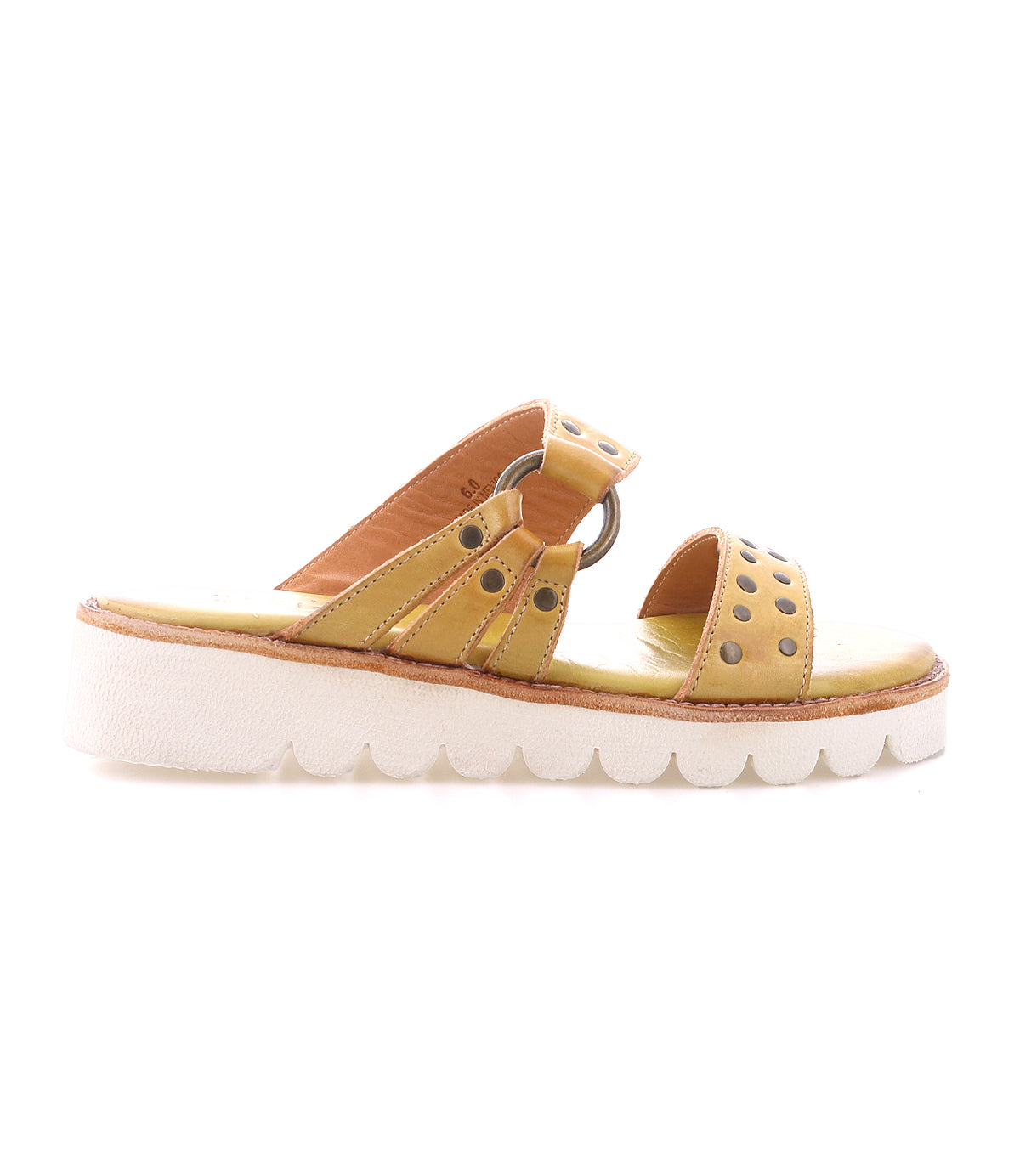 The Bed Stu Chow sandal features distressed brown leather, decorative metal accents, a cushioned tan footbed, and a chunky black platform sole with a wavy pattern.