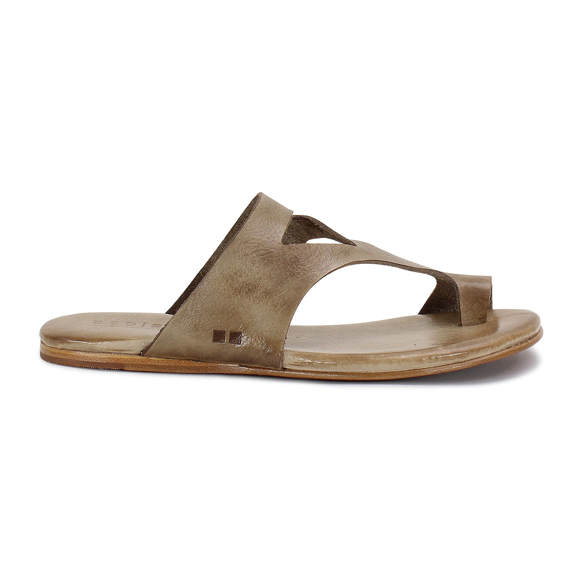 A single brown leather sandal made from vegetable-tanned leather, featuring a cut-out design, flat sole, open toe, and slip-on style, viewed from the side. The product is called Civilized by Bed Stu.