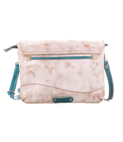 The Cleo by Bed Stu is a light beige crossbody bag with teal accents, a front zipper pocket, and an adjustable strap—an effortlessly versatile clutch for any occasion.
