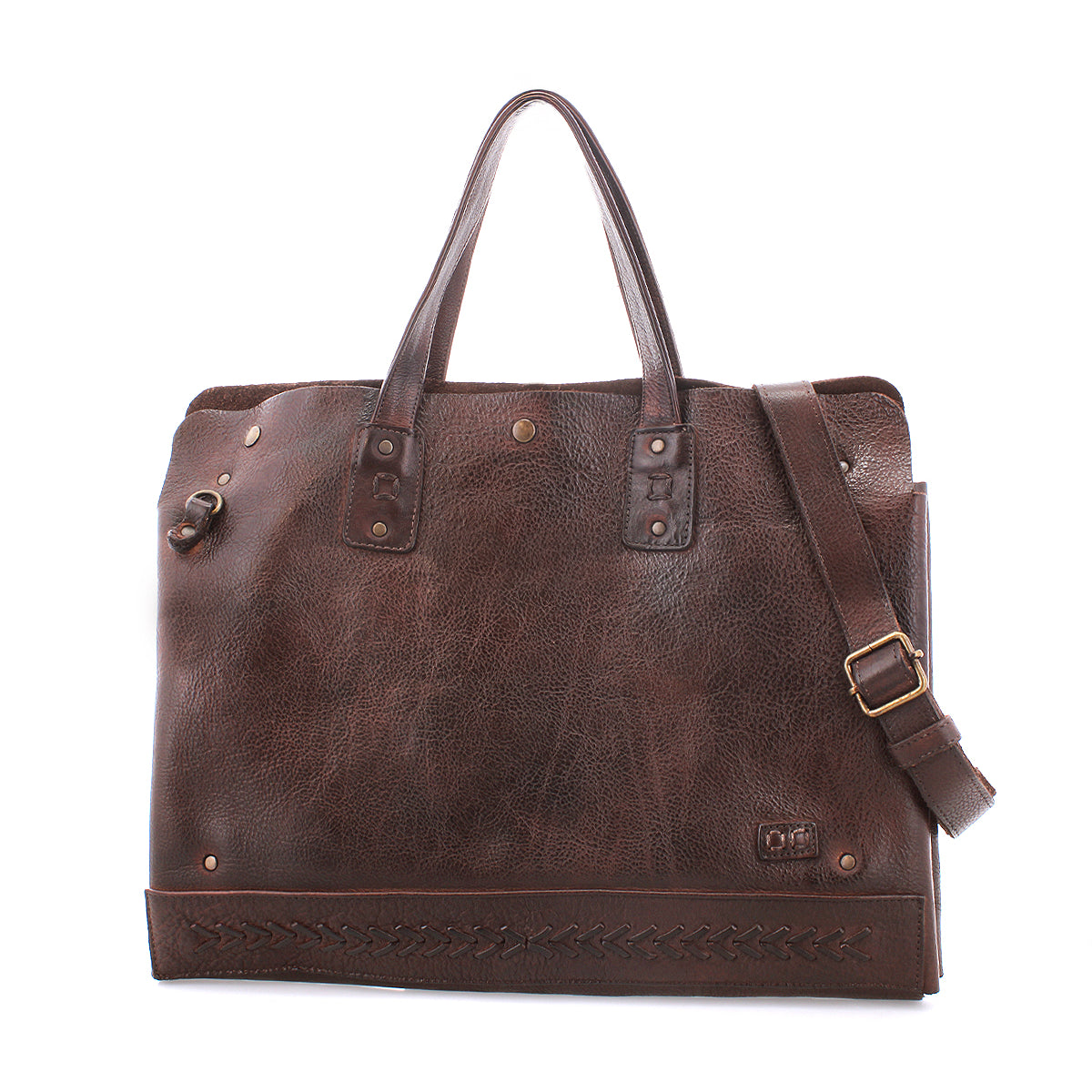 The Bed Stu Commuter is a brown leather tote featuring two handles, a detachable shoulder strap, metal rivets, decorative bottom stitching, and roomy laptop storage—the perfect multifunctional bag for everyday use.