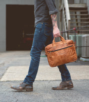 A man carrying a Bed Stu Conclusion laptop bag.