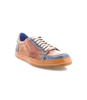 The Bed Stu Condor sneaker features brown and blue leather, durable construction, white laces, a blue interior lining, and a tan rubber sole. Shown at a three-quarter angle on a white background.